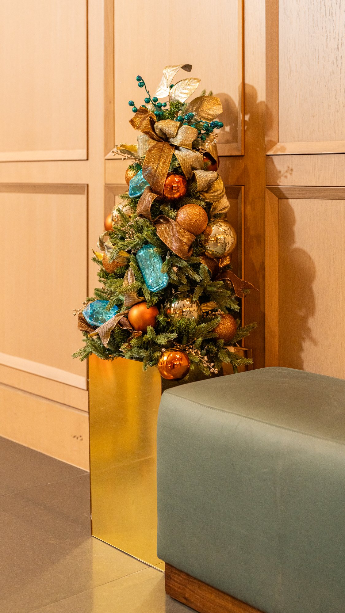 Tabletop tree in champagne gold and aquamarine designed to complement a paneled interior